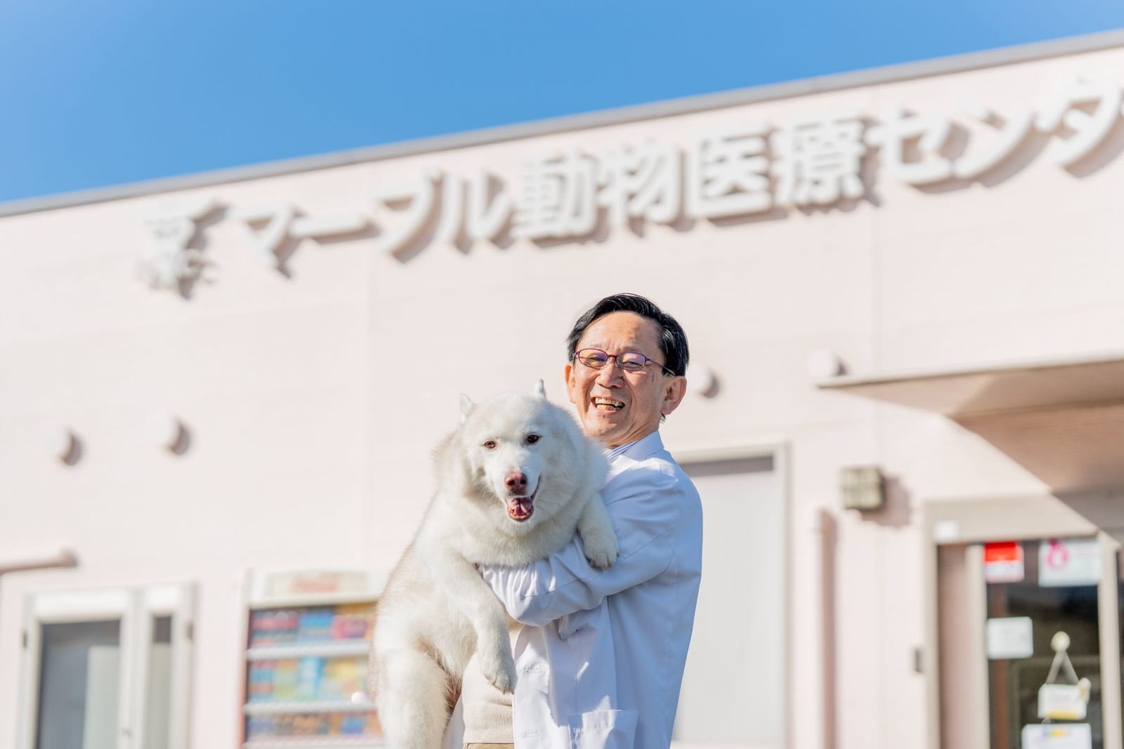 病院の前で犬を抱く、マーブル動物医療センターの院長